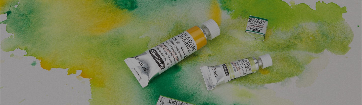 schmincke half pan and tube of paint open on a background of a watercolour painting wash