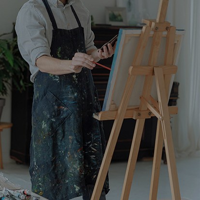 a woman standing at an easel, painting
