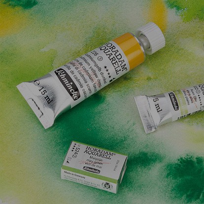 schmincke half pan and tube of paint open on a background of a watercolour painting wash