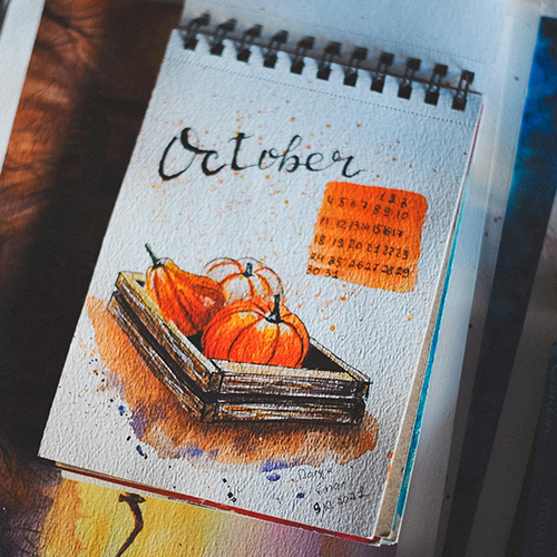 A sketchbook open on a watercolour painting of a p
